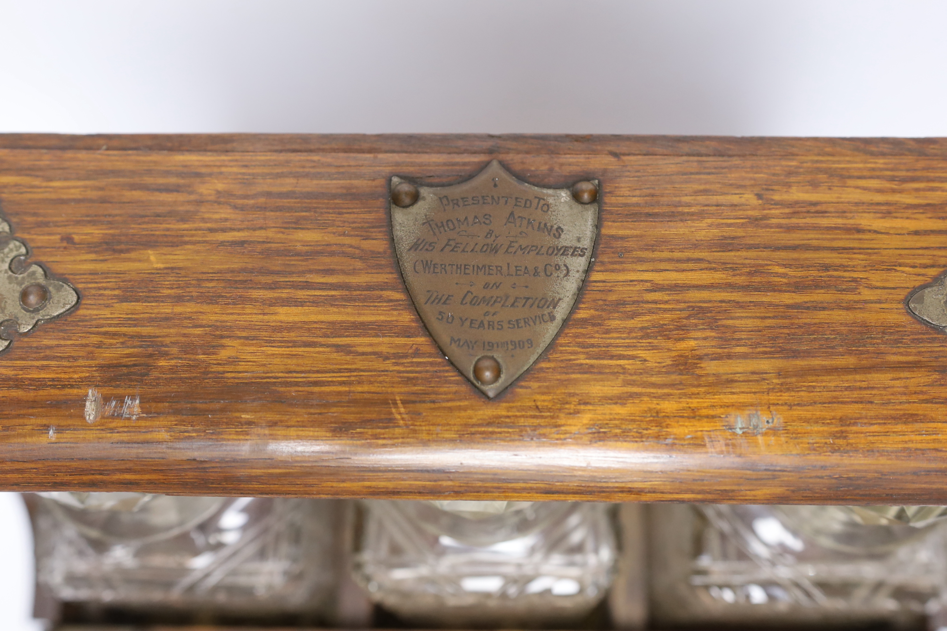 An oak tantalus/compendium containing three cut glass decanters, chess and draught sets, etc.